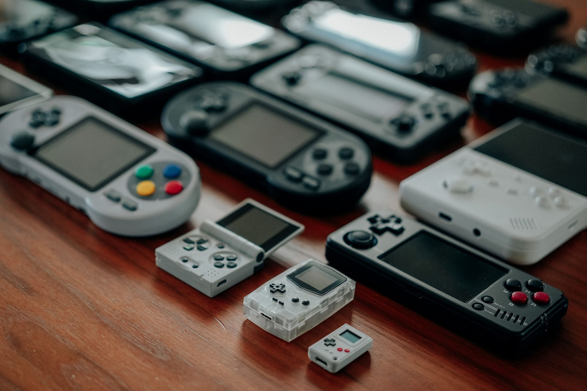Retro handheld consoles on a wooden table